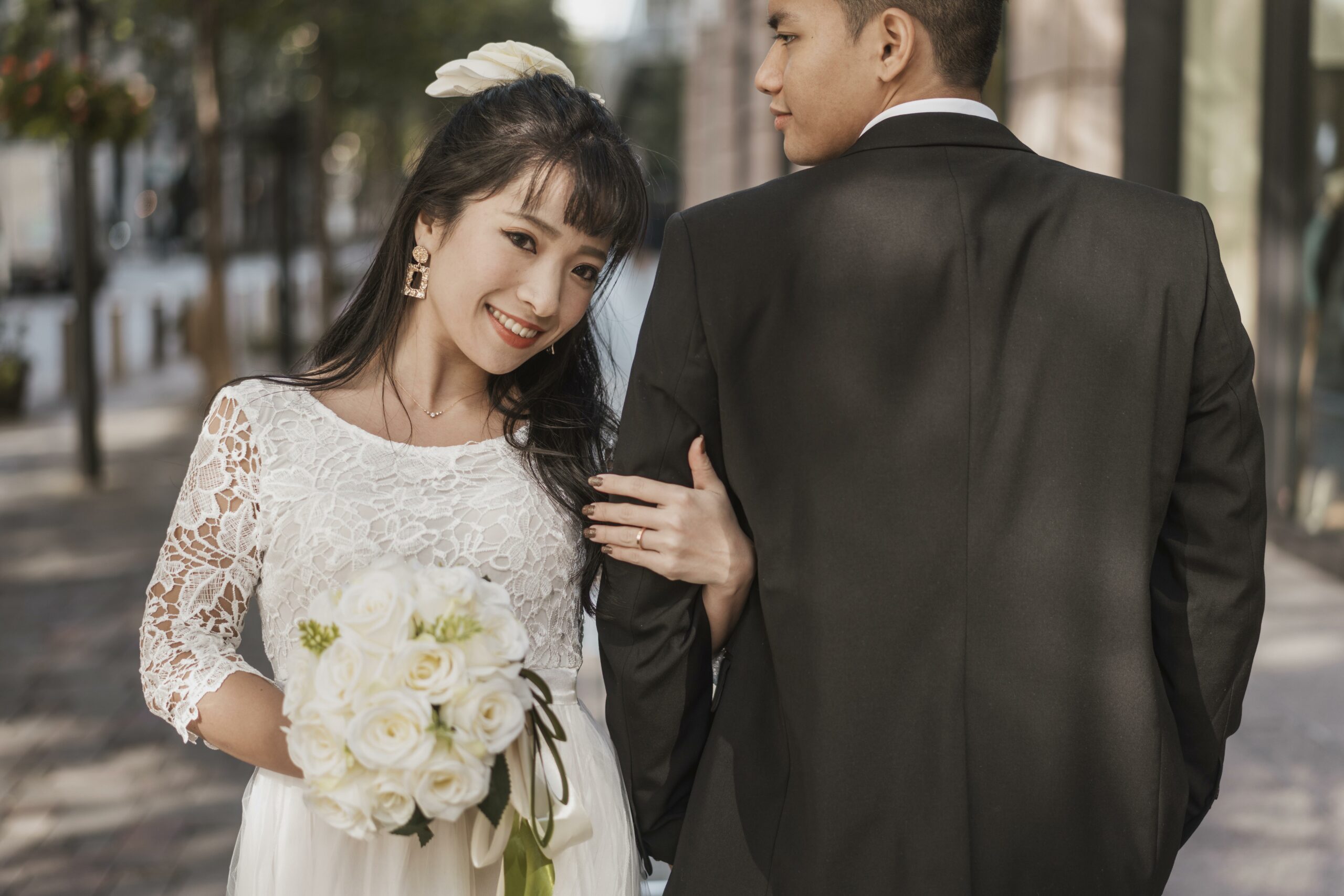 front-view-bride-holding-her-husband-s-hand-outdoors